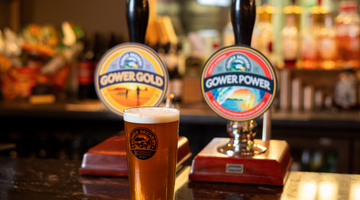 A pint of beer on the bar with Gower Power and Gower Gold cask pumps